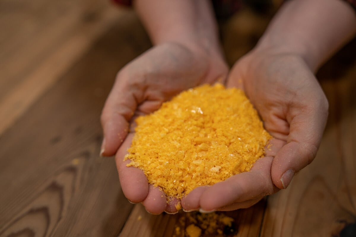 Hands holding a handful of freeze dried eggs.