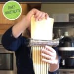 Woman running dough through a pastry cutter for noodles. Text overlay says, "How to Make Egg Noodles"