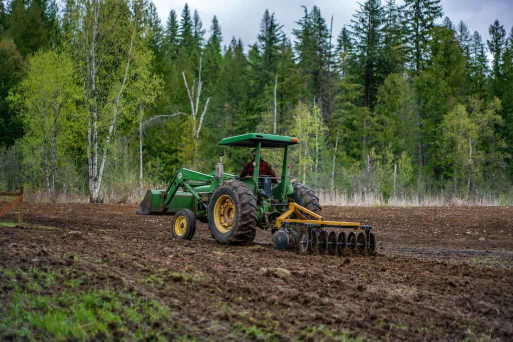 A tractor tilling a field.