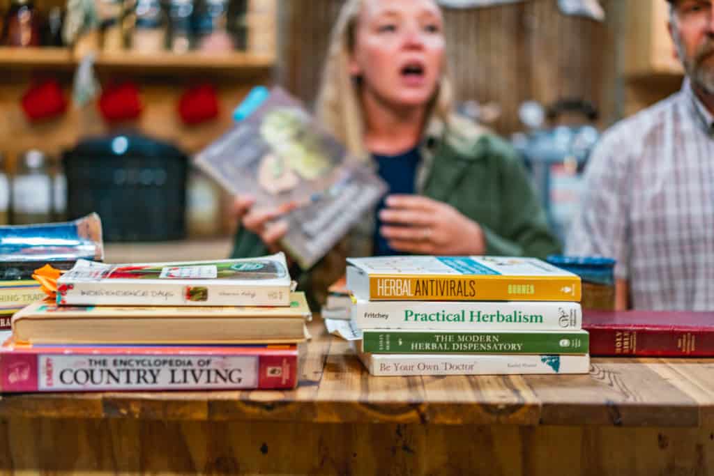 Man and woman sitting in the kitchen with books on the counter in front of them.