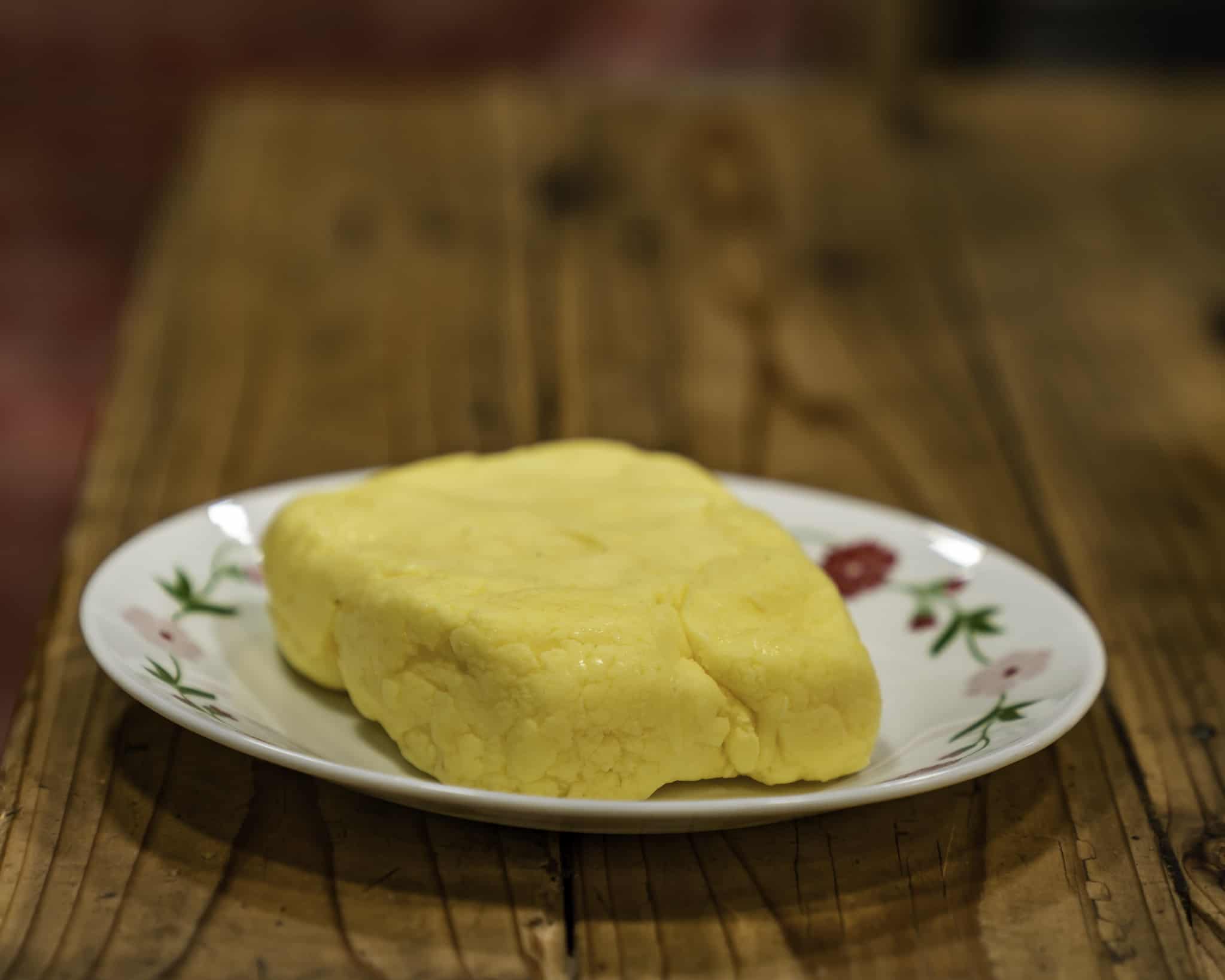 A small plate with a stick of homemade butter.