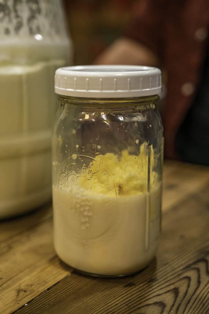 A quart sized mason jar with butter and buttermilk inside.