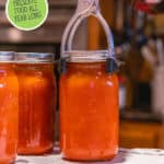 Jars of canned tomato soup. Pinterest pin of what to preserve by month.