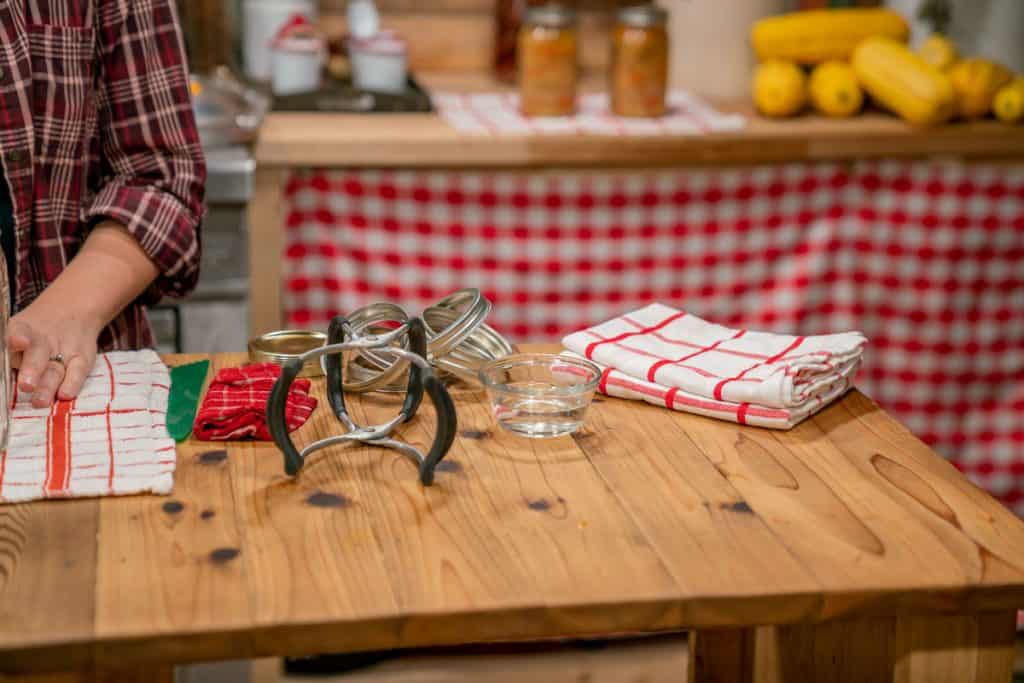 Canning supplies sitting on a wooden counter top.