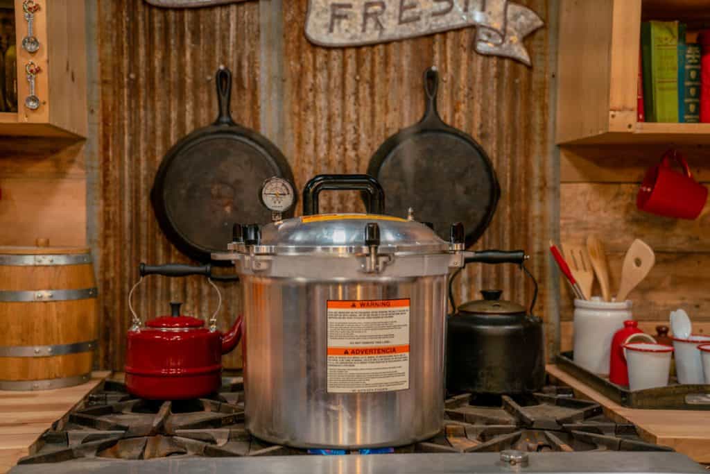 Photo of an all American pressure canner sitting on a gas stove.