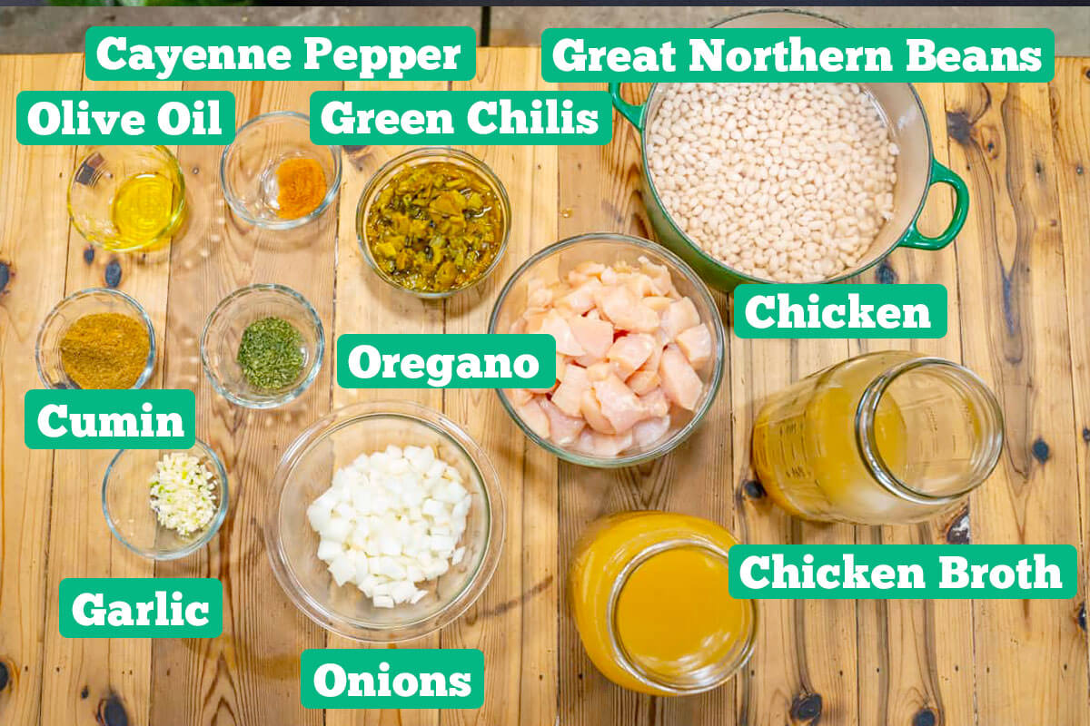 White bean chicken chili ingredients: Great Northern beans, chicken, chicken broth, onions, garlic, cumin, oregano, olive oil, cayenne pepper, and green chilis.