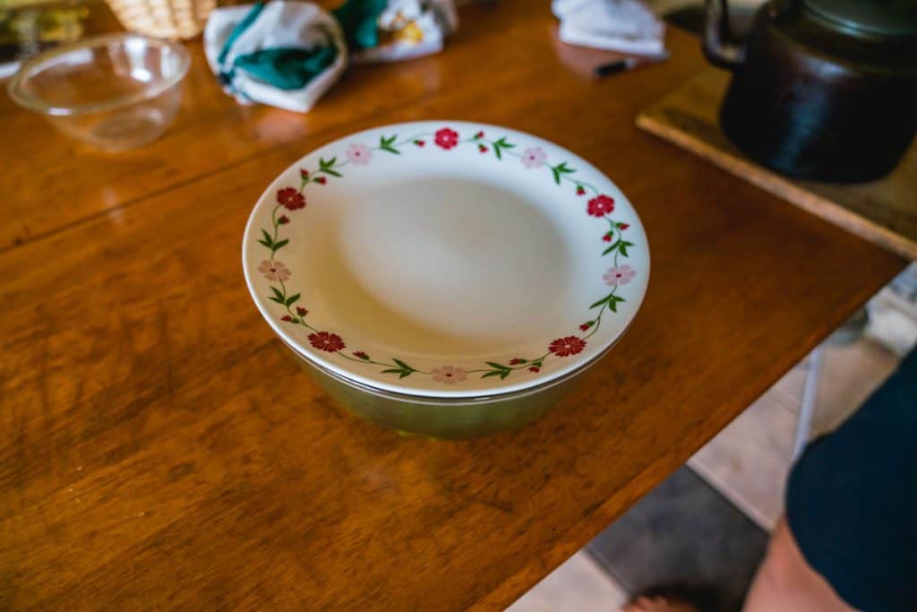 A large bowl with a dinner plate over the top.