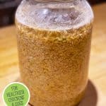 Pinterest pin on how to ferment chicken feed with an image of a gallon jar filled with chicken feed and water.