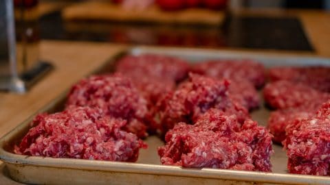 Ground beef patties on a cookie sheet.