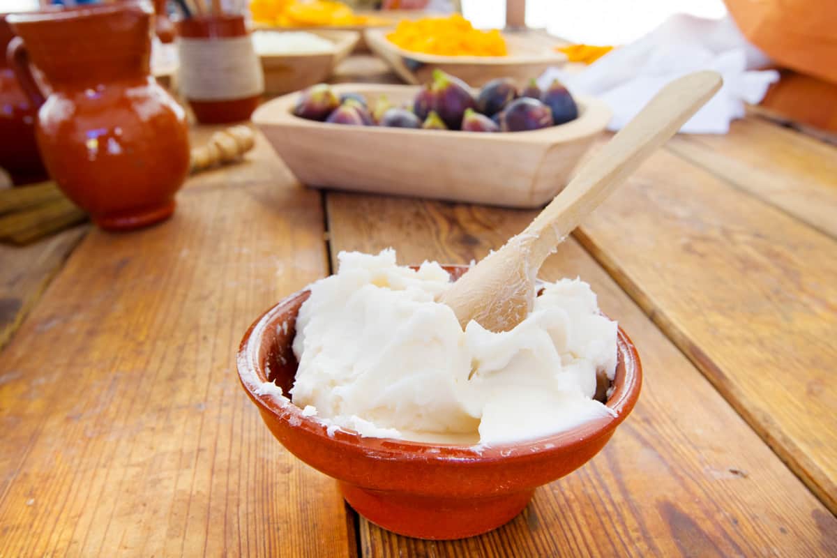 Lard in a bowl with a wooden spoon sitting on a kitchen counter.