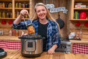 A woman pulling a jar out of the Instant Pot.
