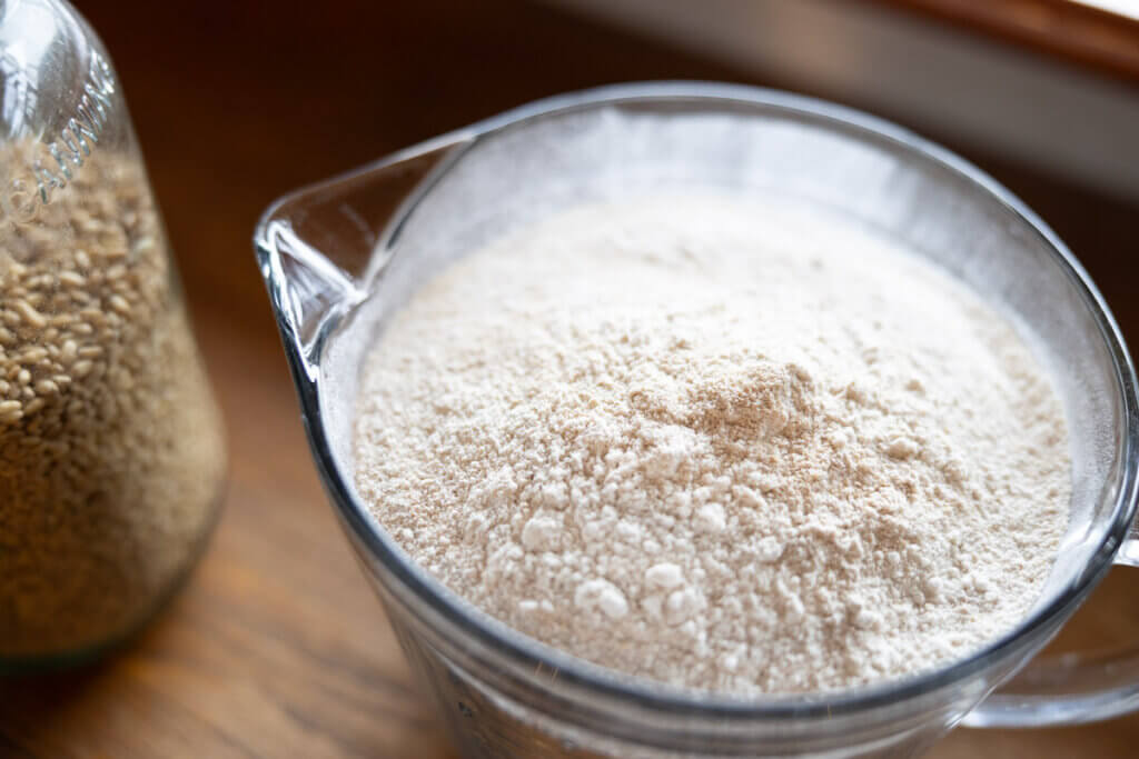 Freshly milled flour in a measuring cup.