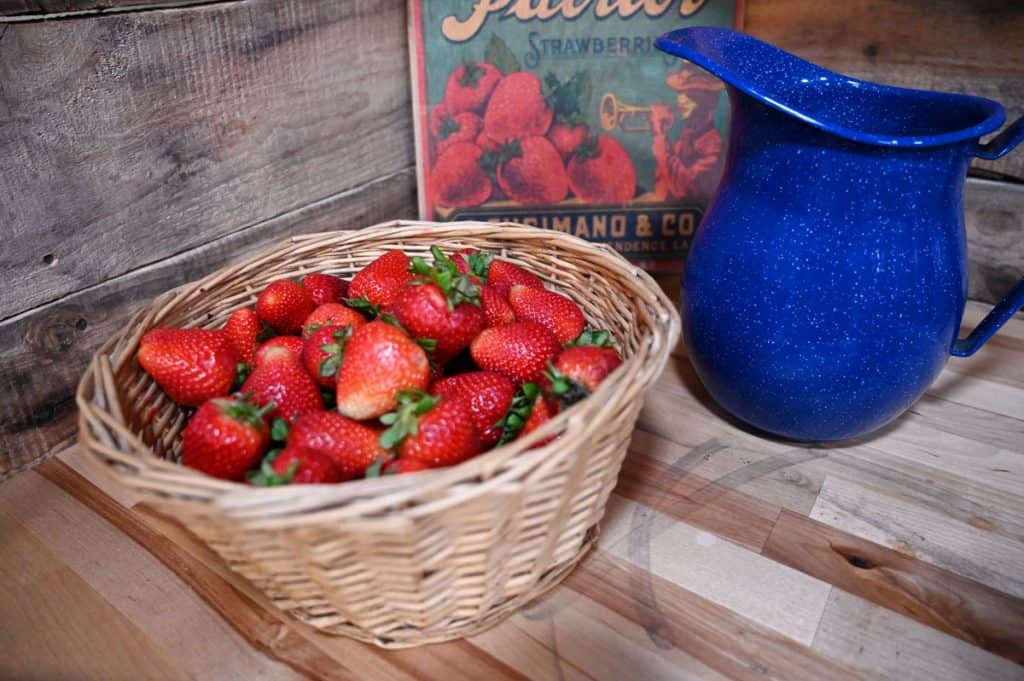 A wicker basket filled with fresh picked strawberries.