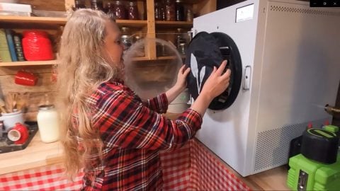 A woman putting the insulation cover onto a Harvest Right freezer dryer.