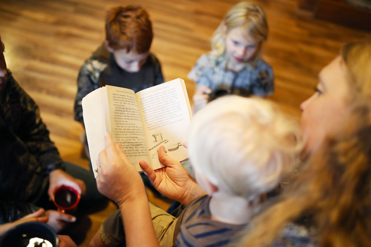 A woman reading to her children.