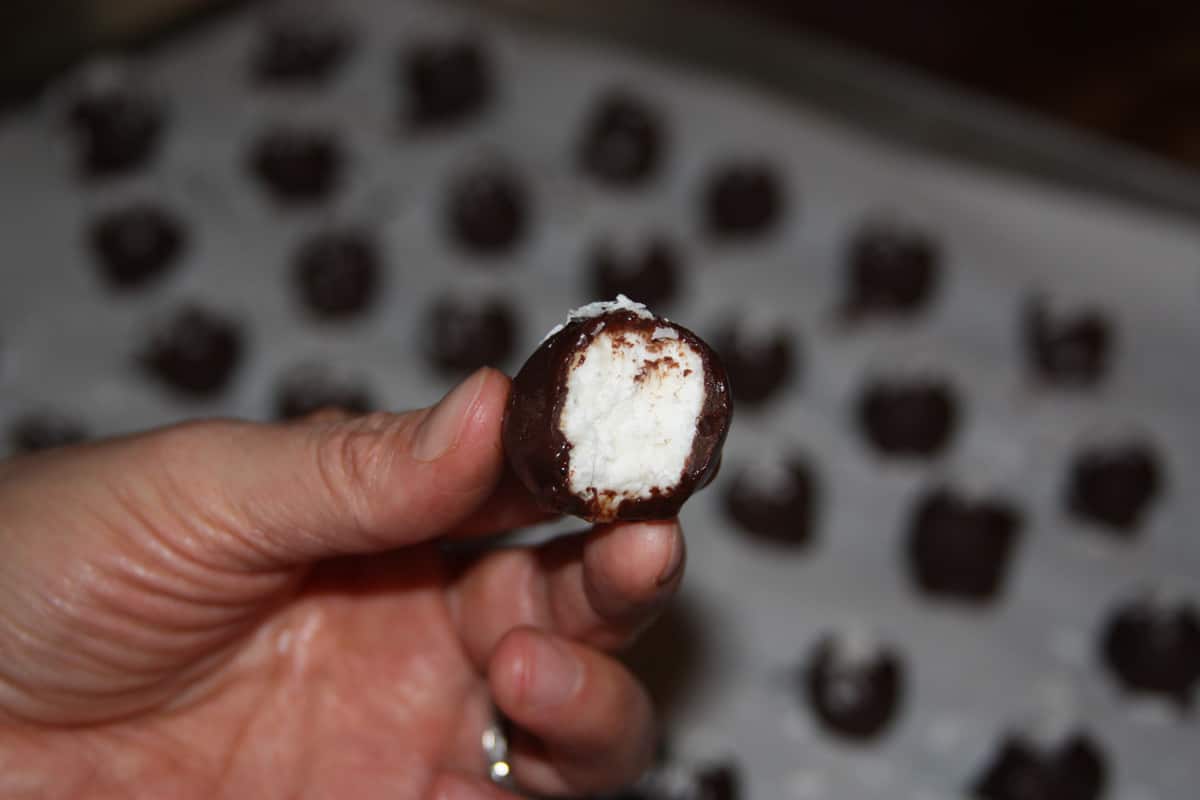 Finished coconut truffle with a bite taken out.