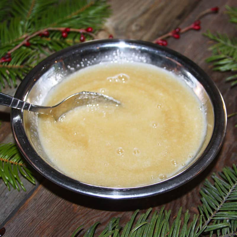 Homemade sugar scrub being mixed in a stainless steel bowl.