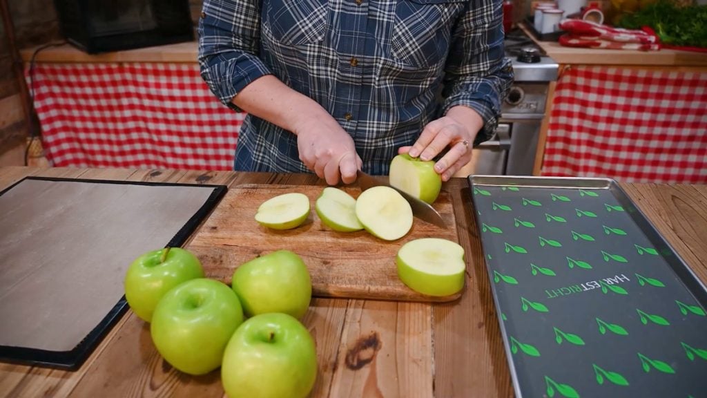 A woman slicing five apples.