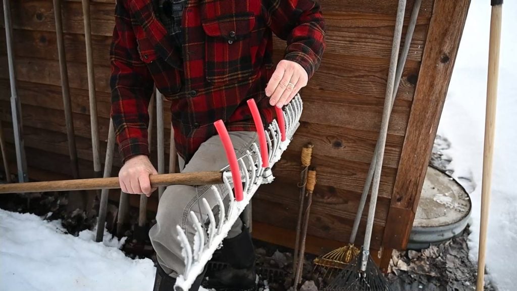 A rake with three pieces of Pex tubing on the tines.