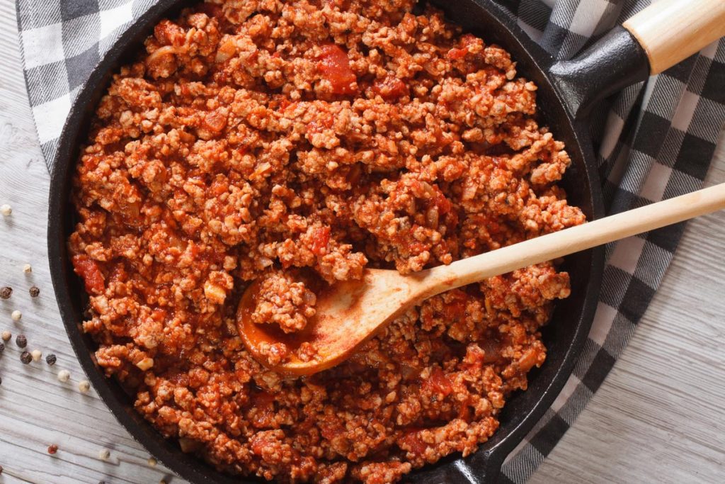 Cooked ground beef with tomato sauce in a pan.
