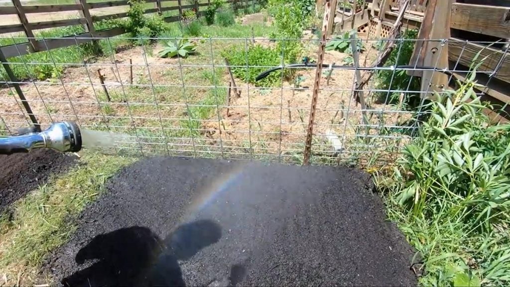 A hose watering a new garden plot.