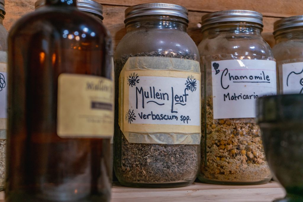 Jars of dried herbs on a counter.