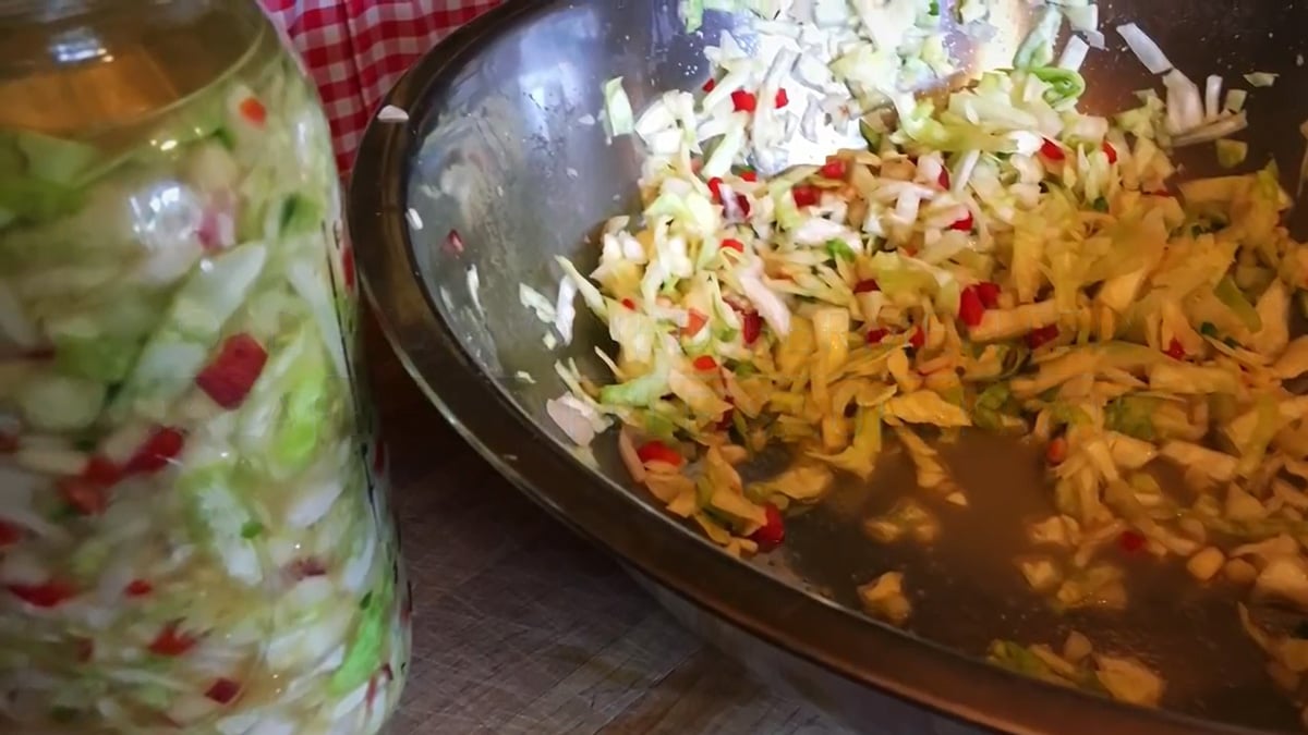 A large bowl of sauerkraut and a jar of sauerkraut.