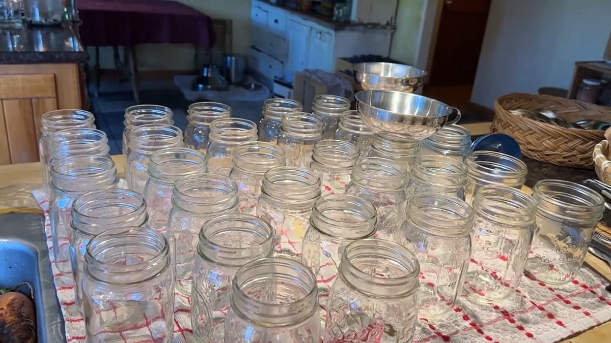 Dozens of empty canning jars lining a counter.