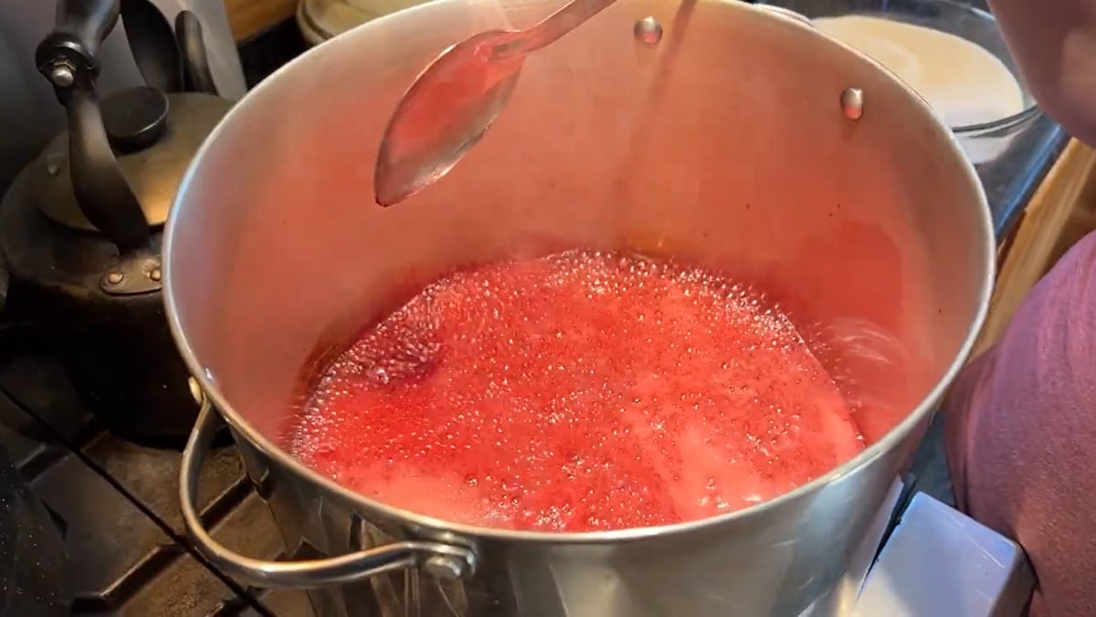Plum jelly boiling in a large stock pot.