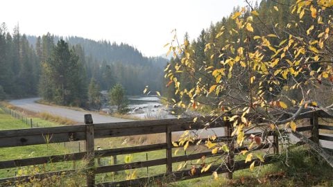 A fence in the foreground and a river in the background.
