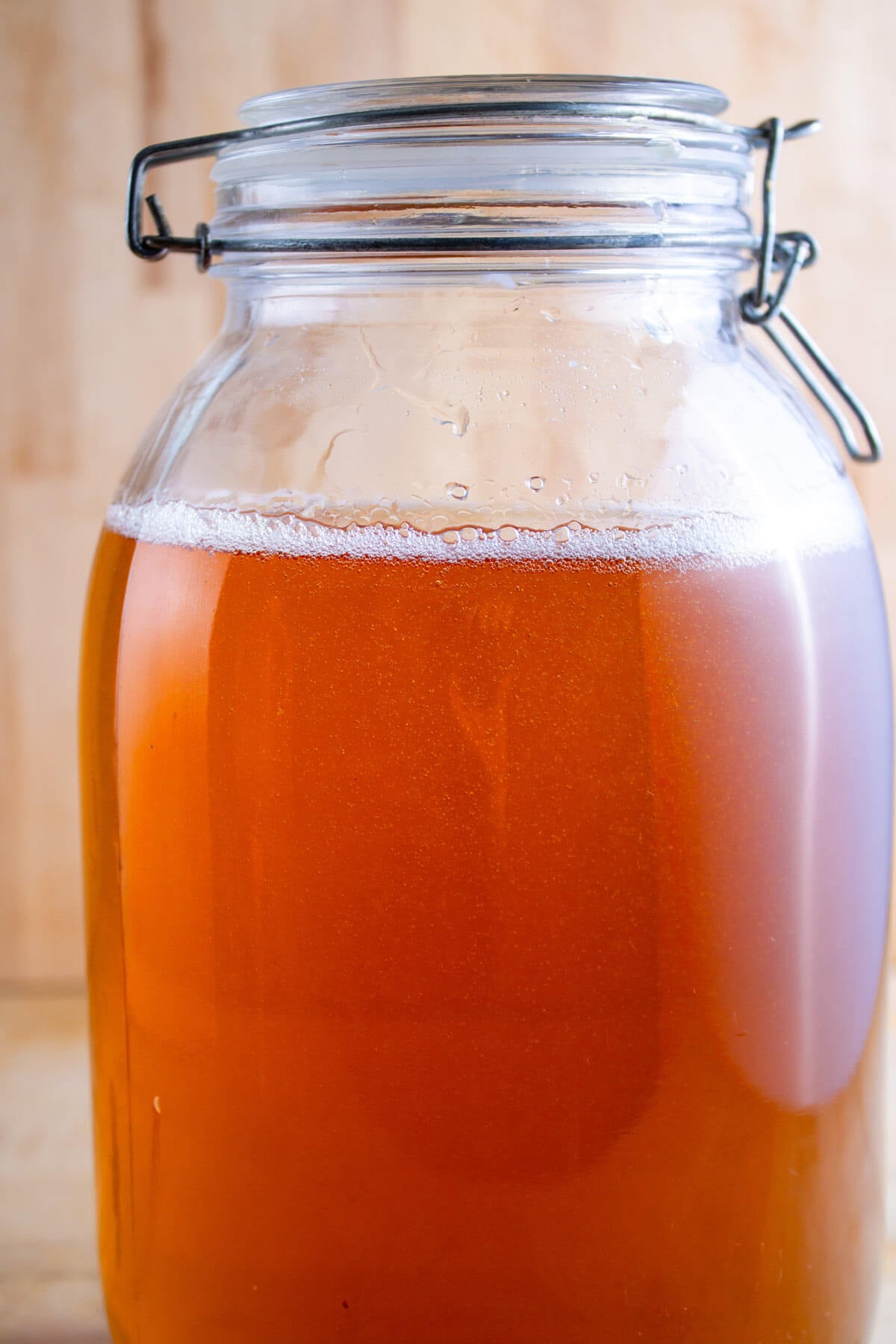 A gallon jar with a flip top lid filled with sparkling apple cider.