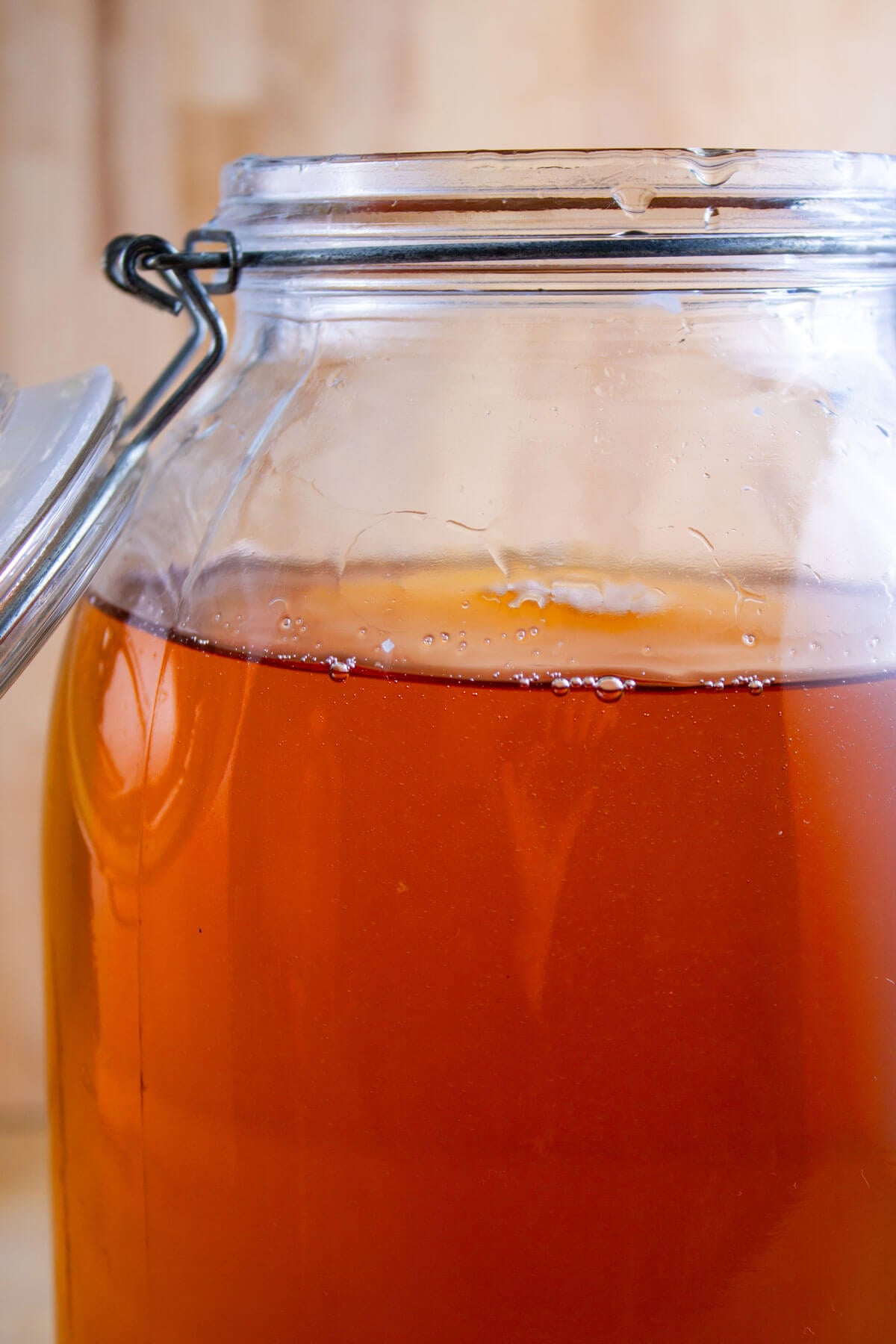 A gallon jar with a flip top lid filled with sparkling apple cider.