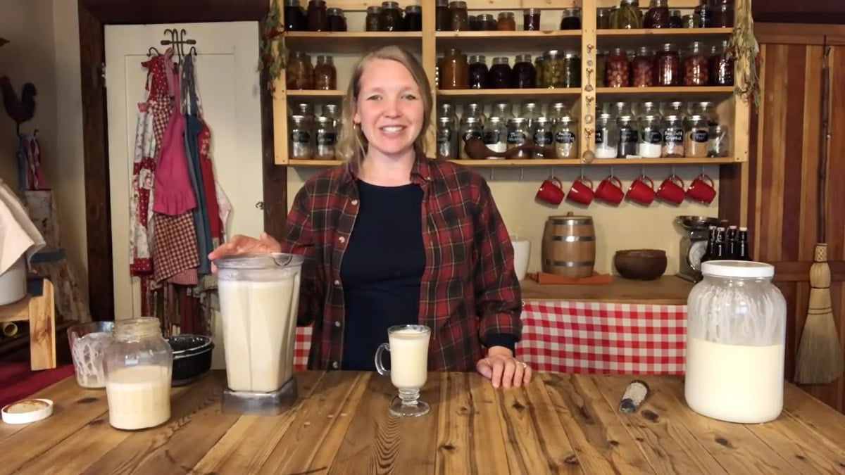 A woman mixing eggnog in a blender.