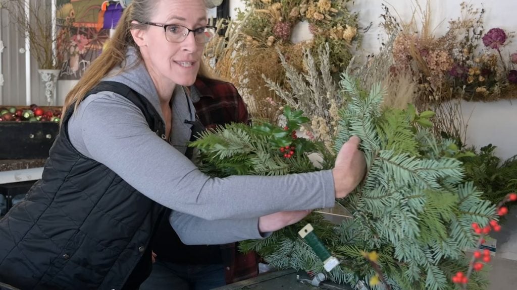 A woman making a holiday wreath.