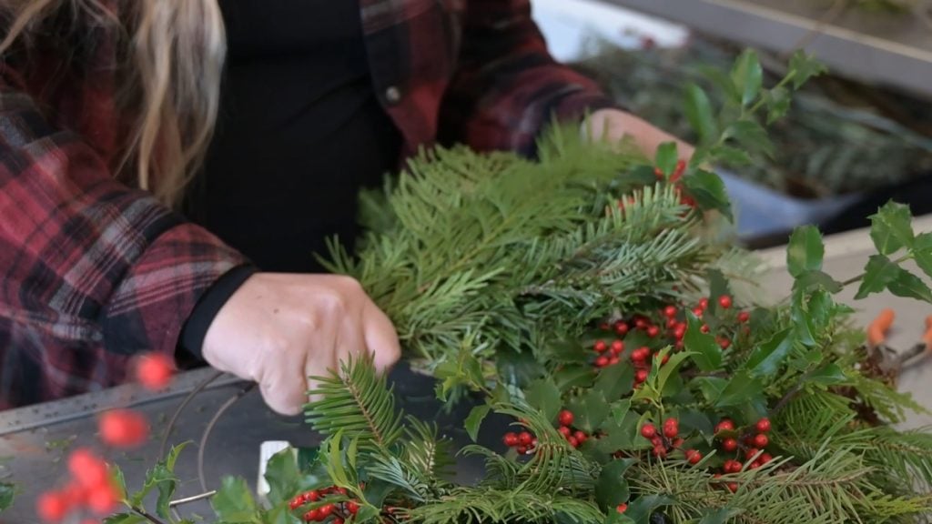 A woman making a holiday wreath.