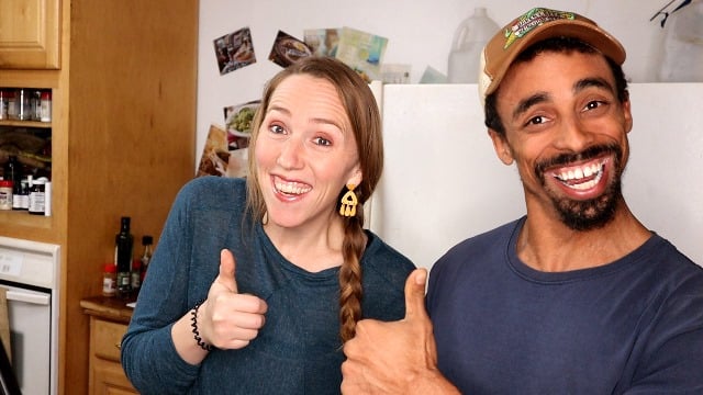 A husband and wife giving thumbs up to the camera.