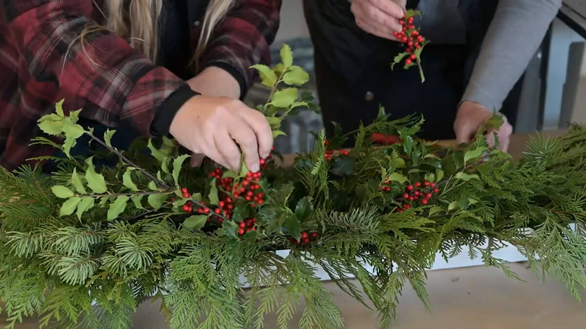 Two women creating a Christmas garland.