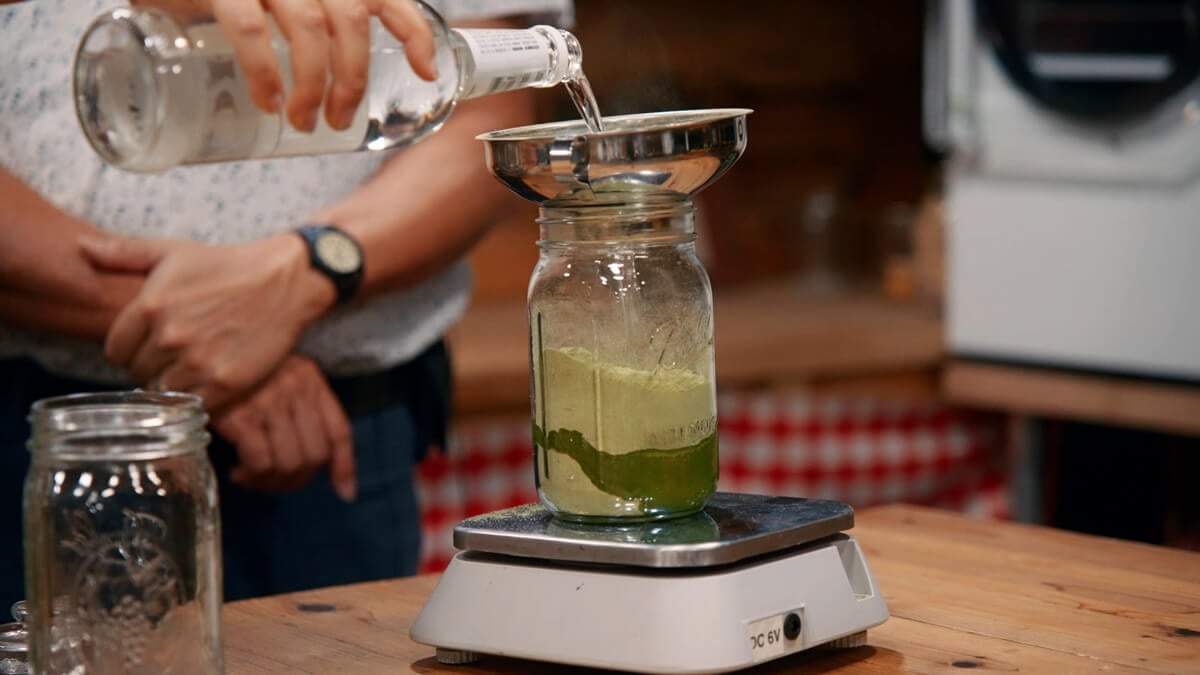 Vodka being added to powdered hops.