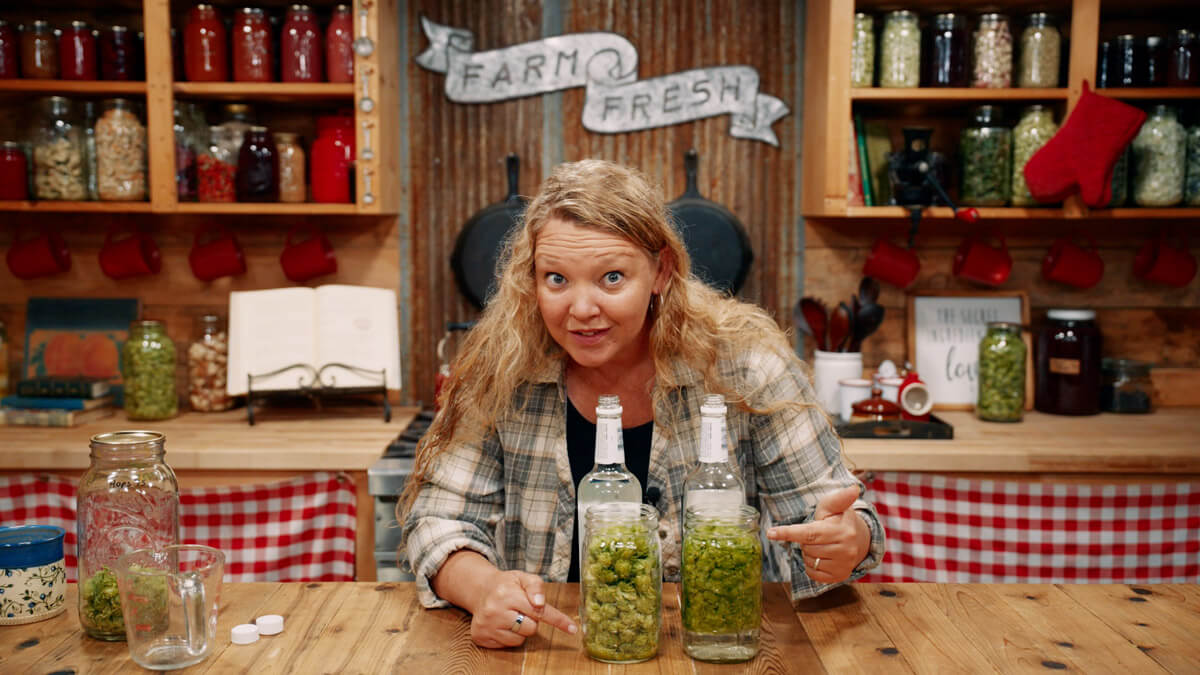 A woman pointing to two jars of hops tinctures.