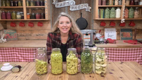 A woman with freeze dried food in jars in front of her.