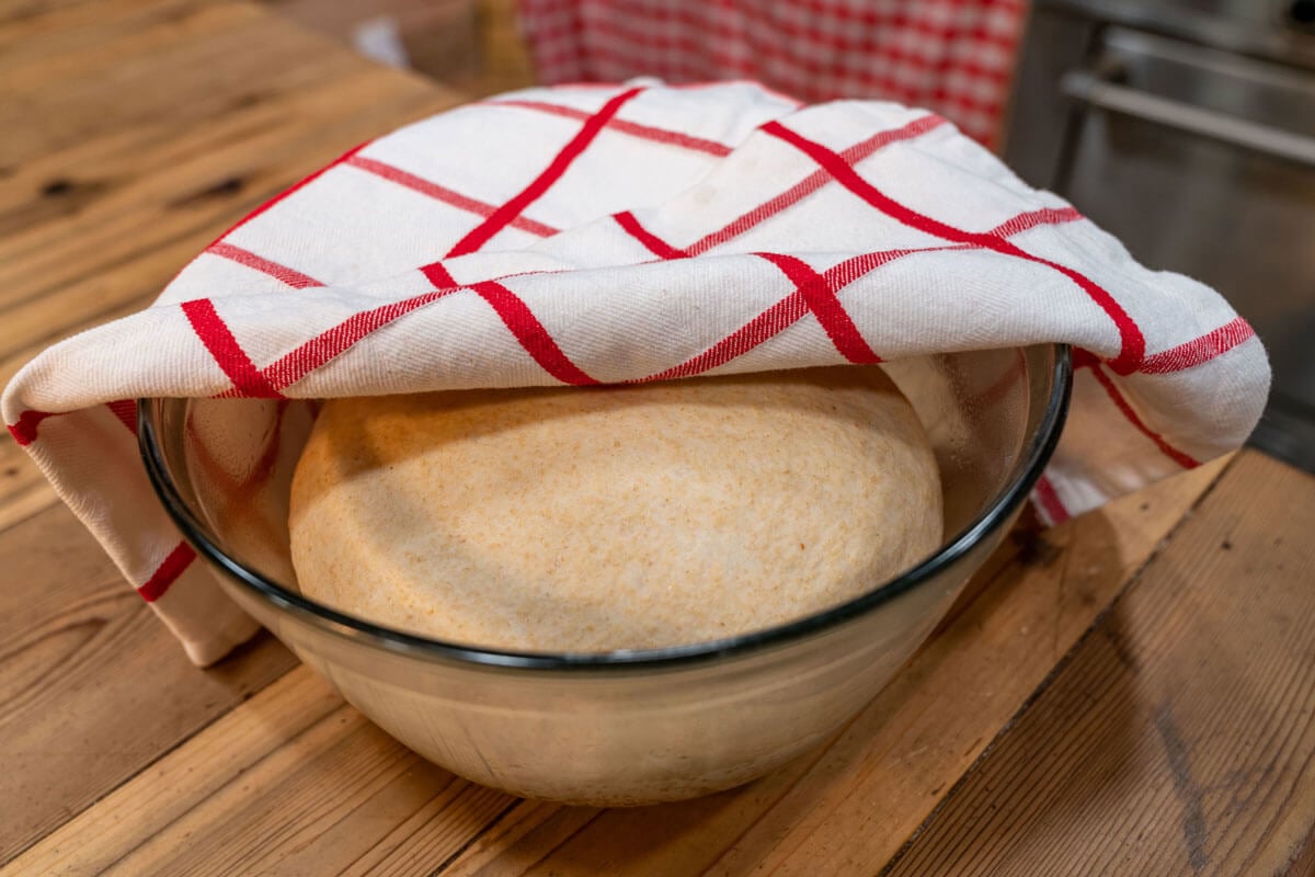 A glass bowl with bread dough rising.