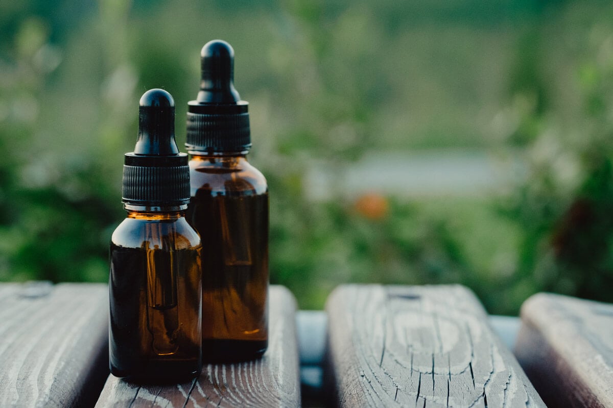 Two amber dropper bottles sitting on a table.