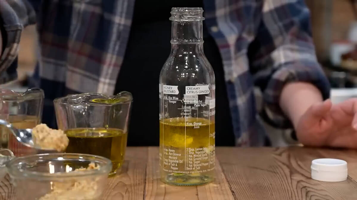 A salad dressing bottle with vinaigrette ingredients.