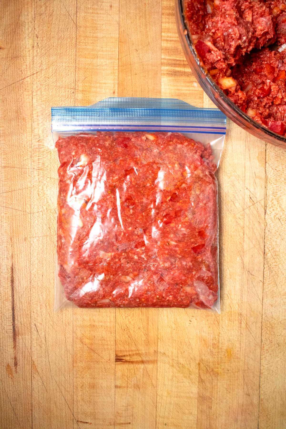 Raw meatloaf mixture sealed in a clear freezer bag.