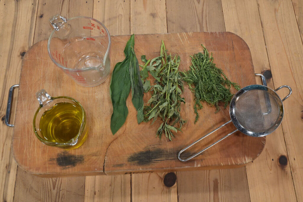 Herbs and oil on a cutting board.