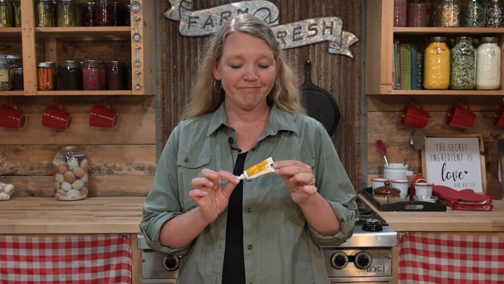 A woman holding up a tube of Neosporin.