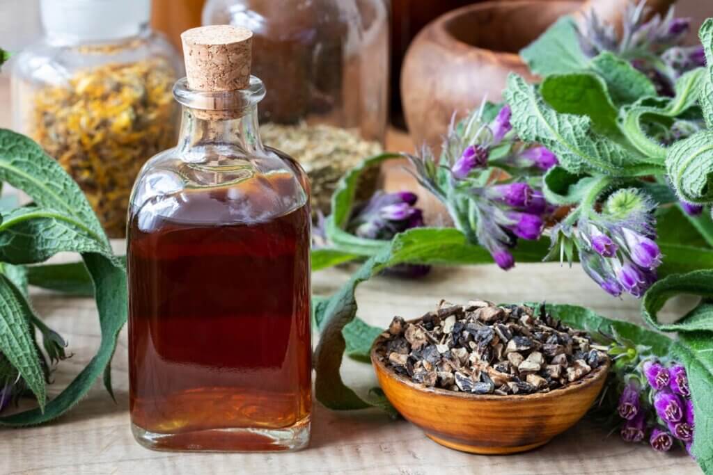 Comfrey oil in a jar with other medicinal herbs.