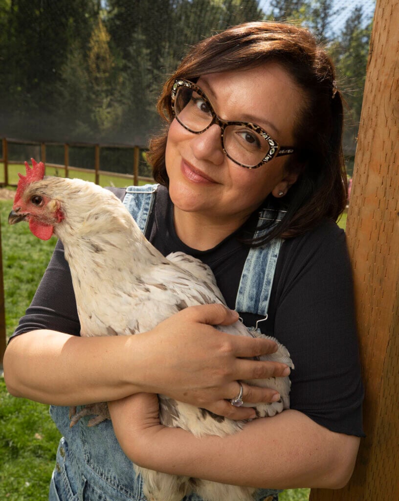 A woman holding a white chicken.