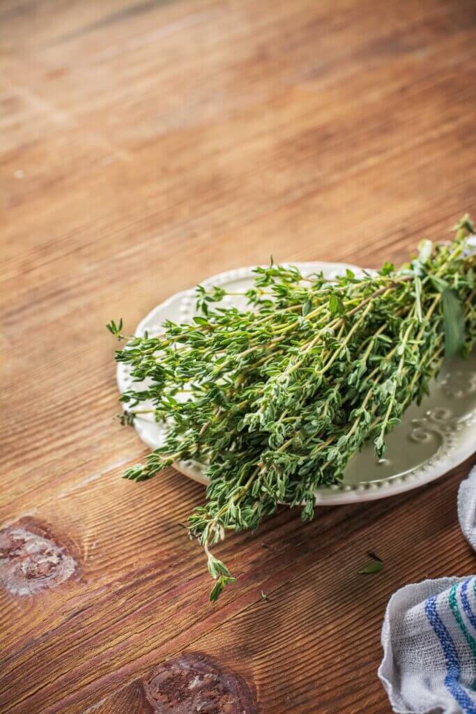 Bundled thyme on a white plate.