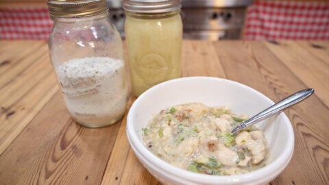 Cream of chicken soup in a white bowl on a wooden counter.
